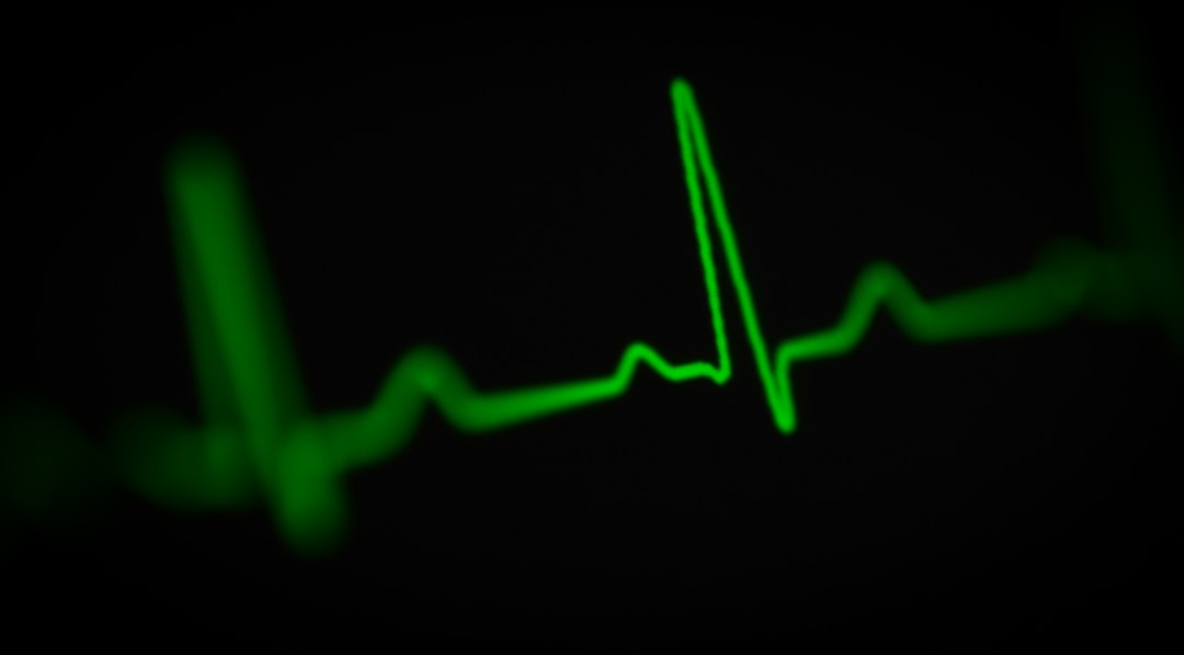 A close-up of a heart rate monitor sensor on a finger, showing the pulse reading in real time