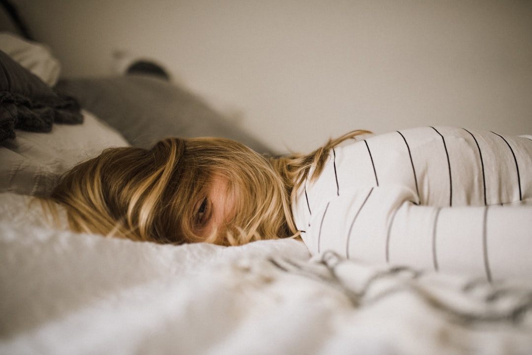 A person awake at night in dim light, representing the insomnia and uncertainty that smart rings often misclassify as light sleep