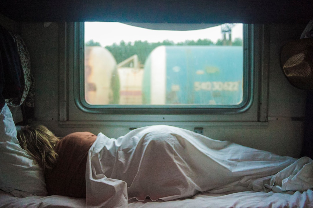 A traveler sleeping on a train, illustrating how travel and unfamiliar environments create unique physiological conditions that most wearables cannot distinguish from actual poor sleep