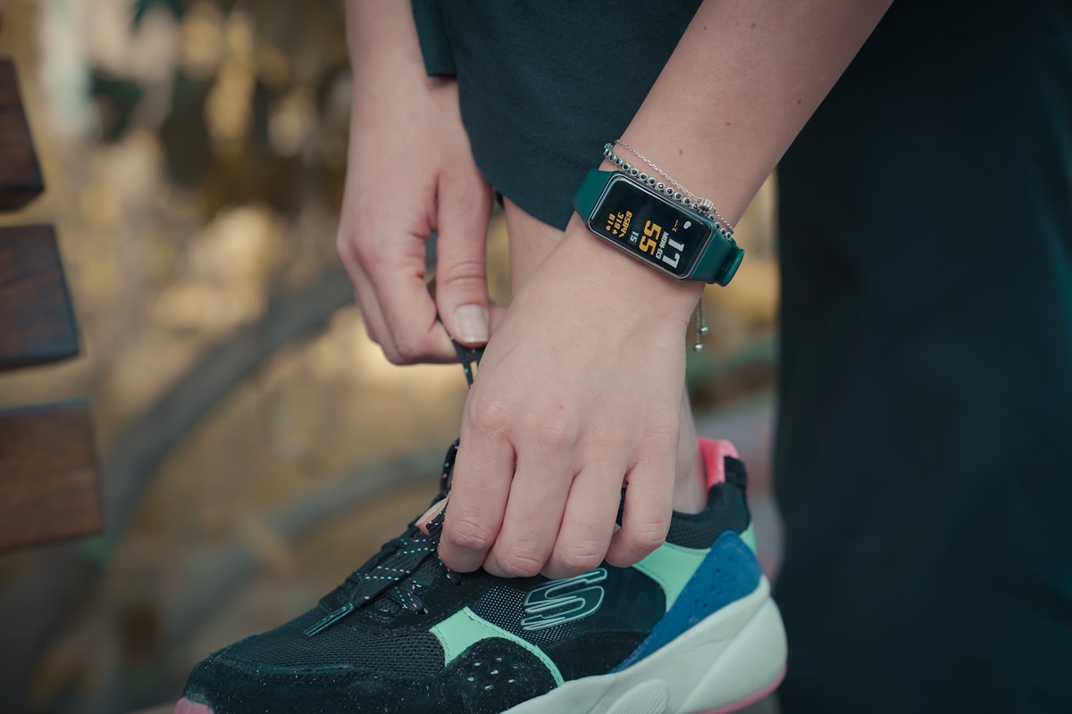 A fitness tracker on a clean modern desk, representing the hardware that has become a loss leader for subscription services