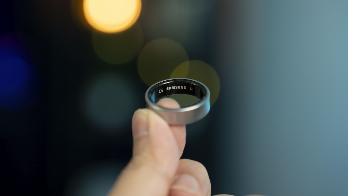 A dark metallic smart ring on a textured surface, representing the last independent hardware in an industry racing toward subscriptions
