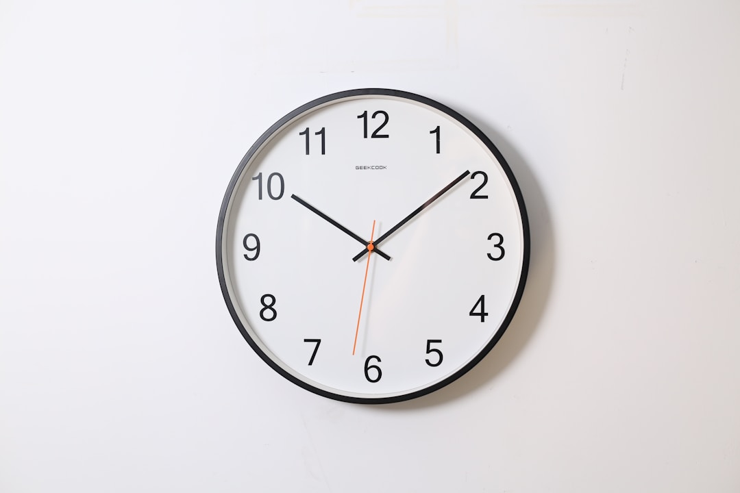 A person lying in bed with an alarm clock showing early morning hours, illustrating the disconnect between weekday alarms and weekend sleep schedules