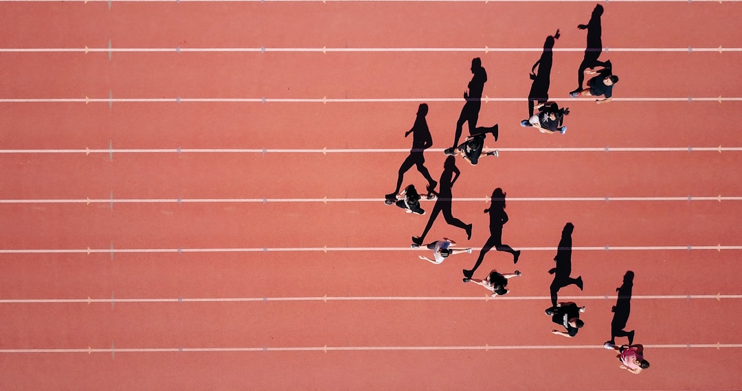 A runner on a track at sunset, the exact scenario where smart ring heart rate tracking fails due to finger blood flow physics