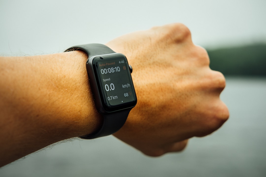 A runner checking a wrist smartwatch during a workout, the device that handles exertion better than any finger-worn sensor could
