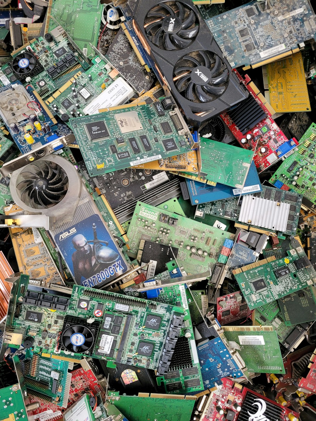 A pile of discarded smartphones and electronics in a recycling facility, illustrating the scale of wearable e-waste that grows when devices are designed without repair paths