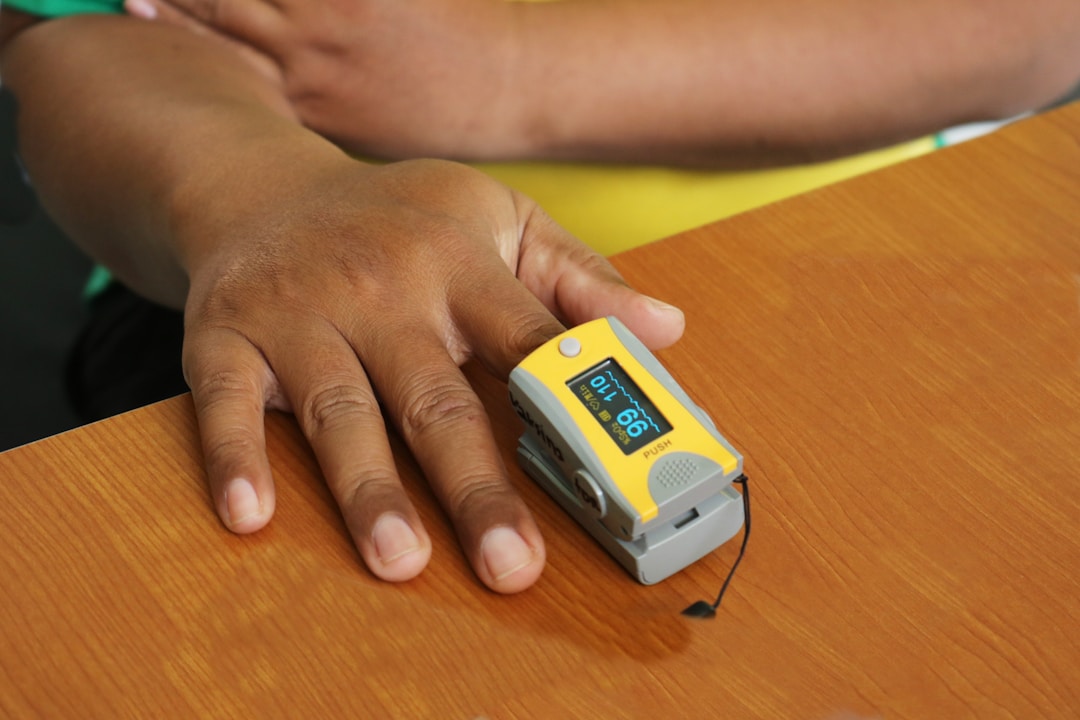 A medical pulse oximeter clipped to a fingertip, using transmissive light technology that consumer smart rings cannot replicate