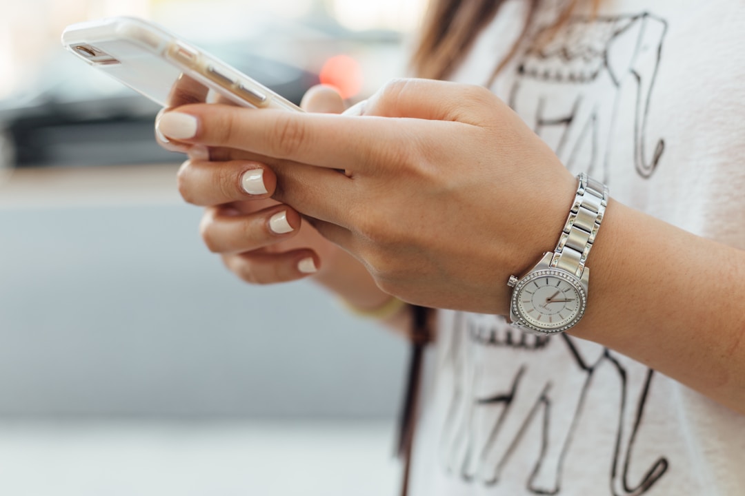 A woman checking her phone in private. The exact moment where health data crosses from personal to uploaded, and from uploaded to subpoenable